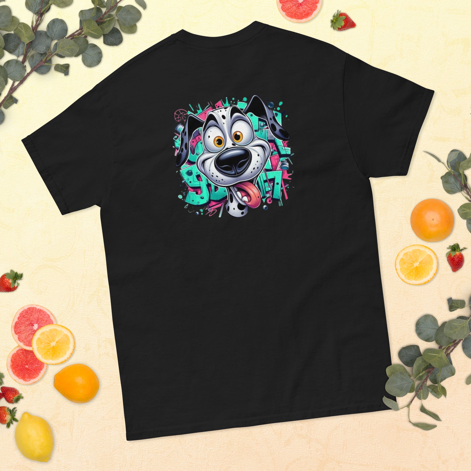 Black t-shirt with a colorful dog graphic on a beige background with fruits and leaves.