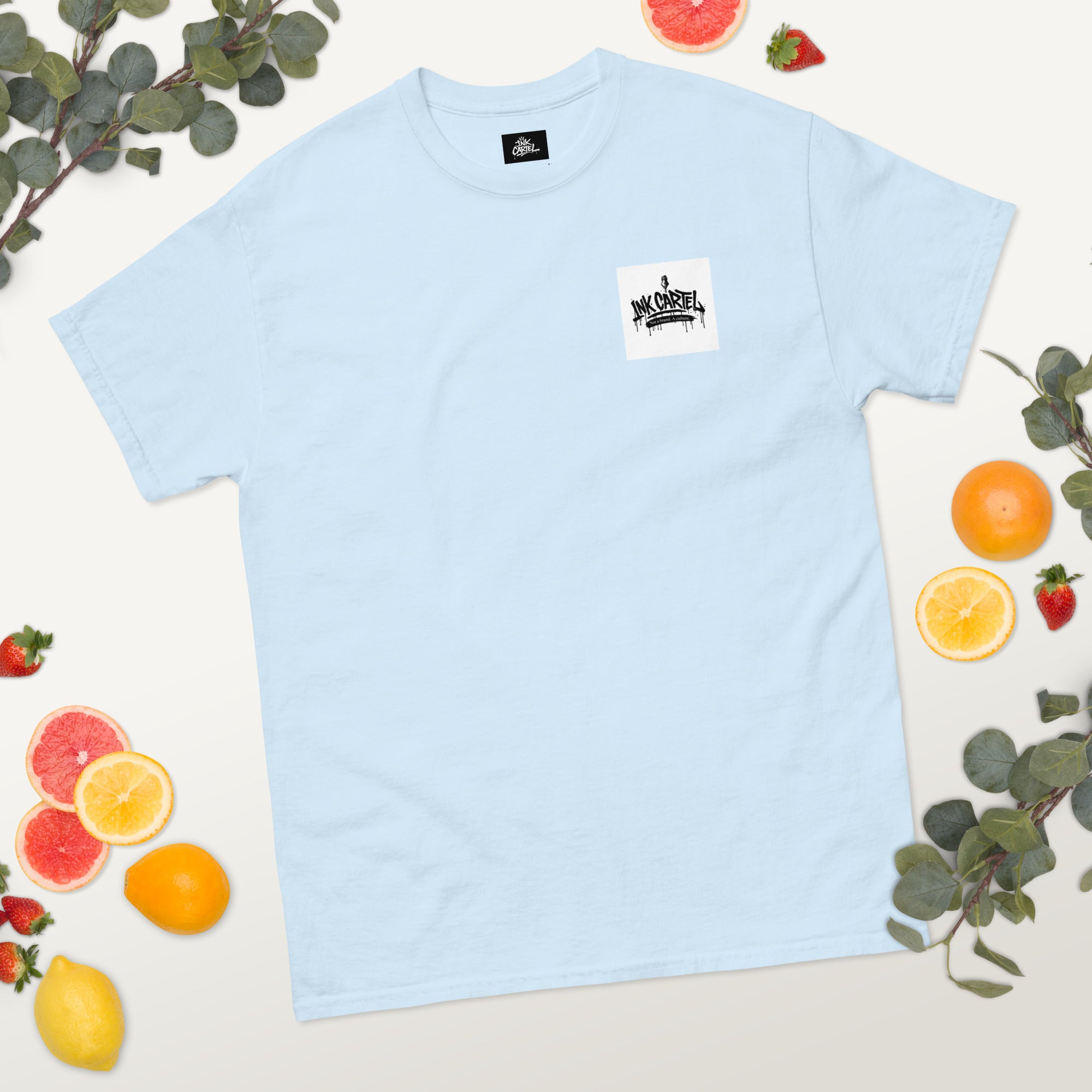 Light blue t-shirt with a logo on a white background with fruits and leaves.