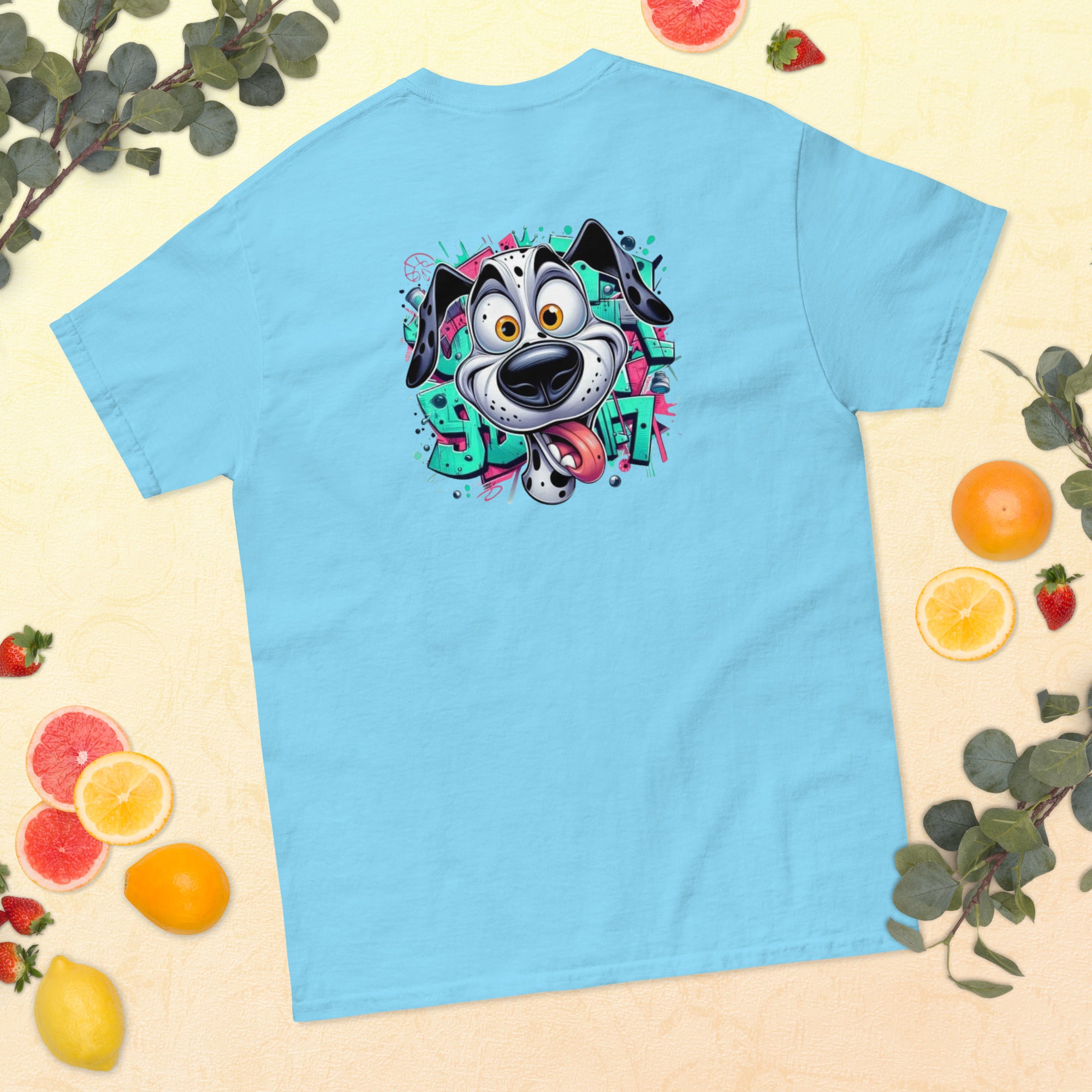 Light blue t-shirt with a colorful dog graphic on a yellow background with fruits and leaves.