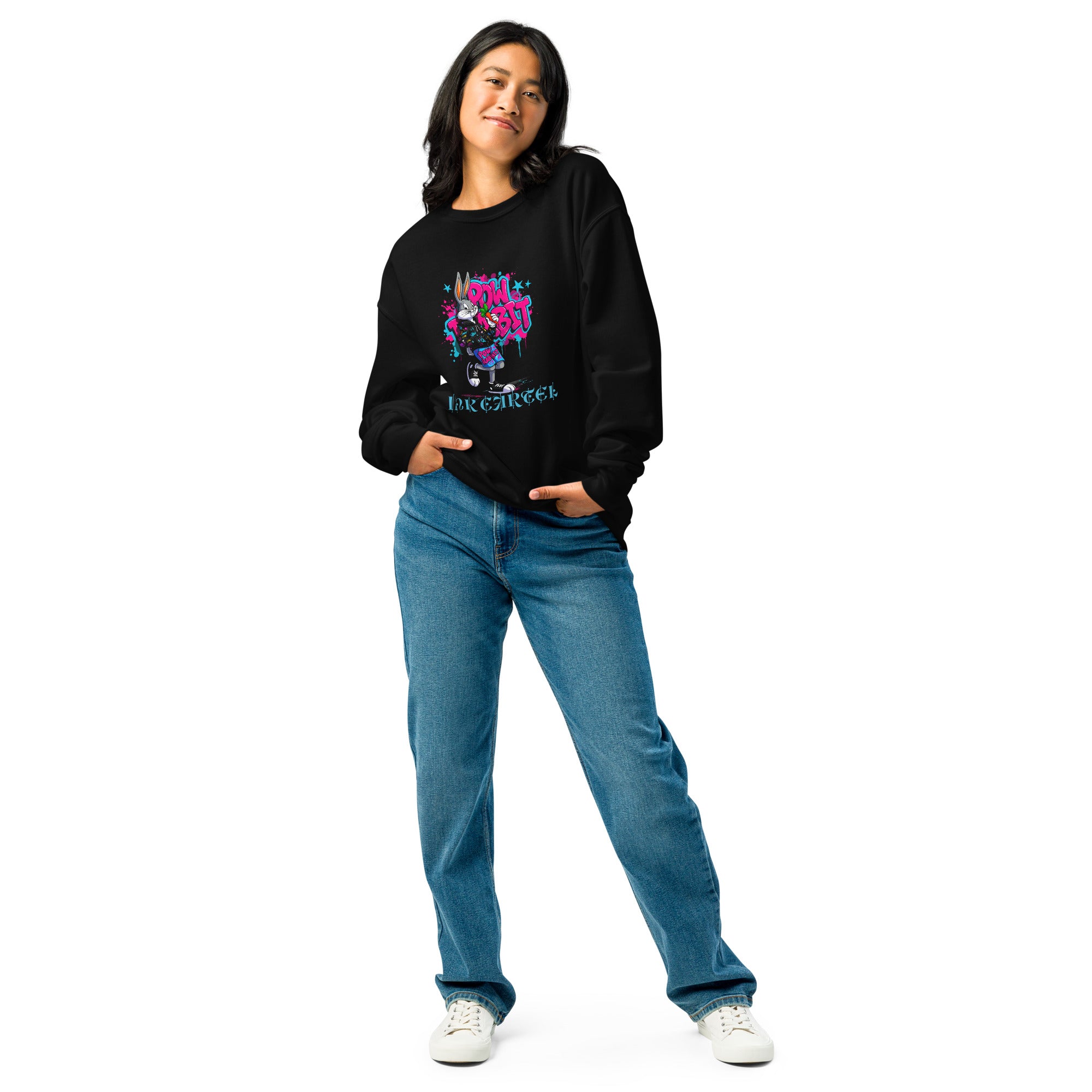Person wearing a black sweatshirt with colorful design and text, blue jeans, and white sneakers on a white background