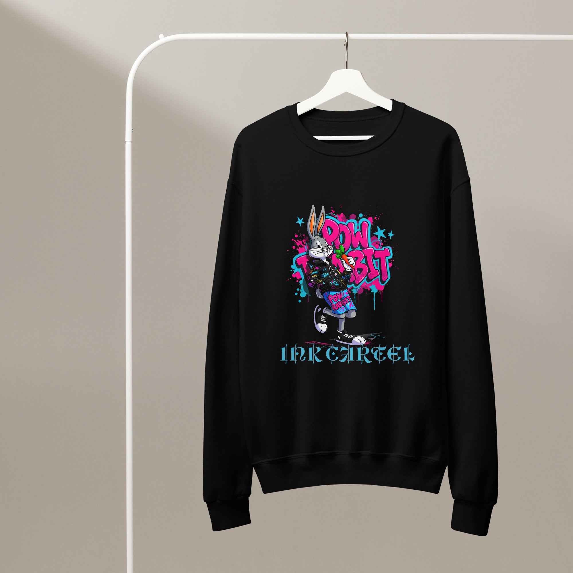 Black sweatshirt with colorful graphic design on a hanger against a beige background